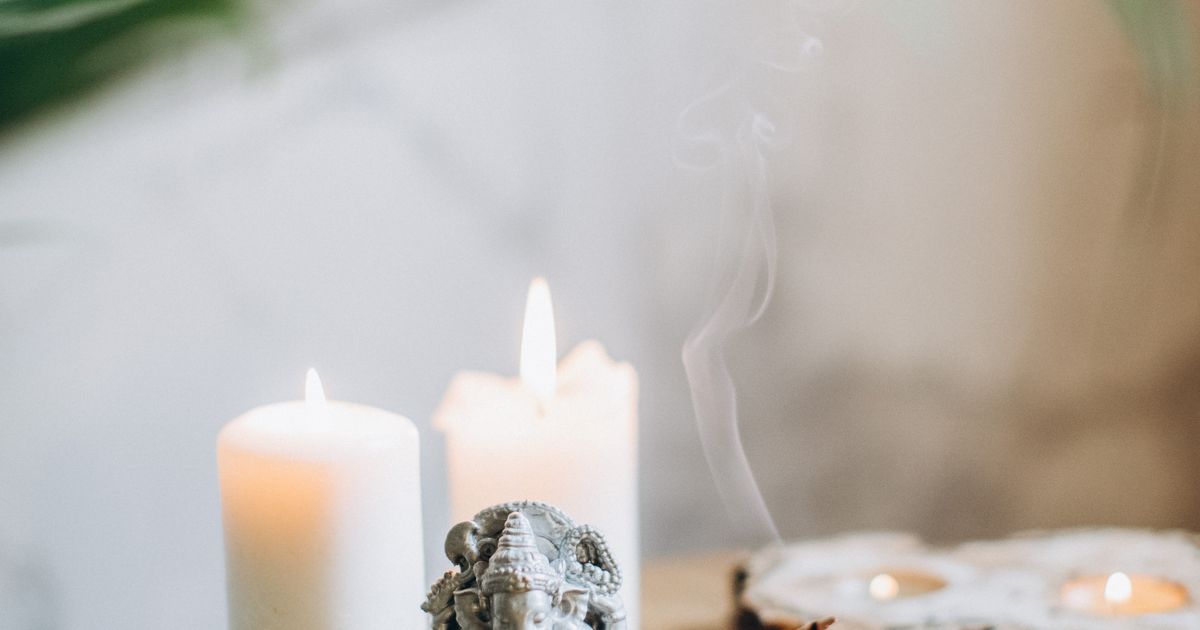 Duhovni i meditativni predmeti – kip Buddhe, mala perle, biljke za okađivanje i oltar u mirnom interijeru