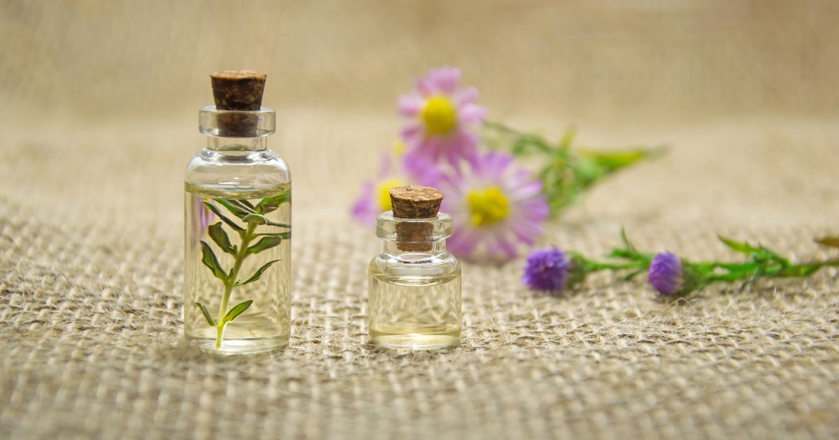 Eterična ulja u staklenim bočicama s biljkama i difuzorom, aromaterapija kod kuće