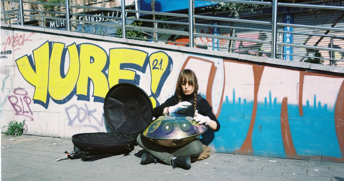 Handpan, metalni instrument u obliku dvije spojene zdjele, položen na noge svirača tijekom sviranja rukama