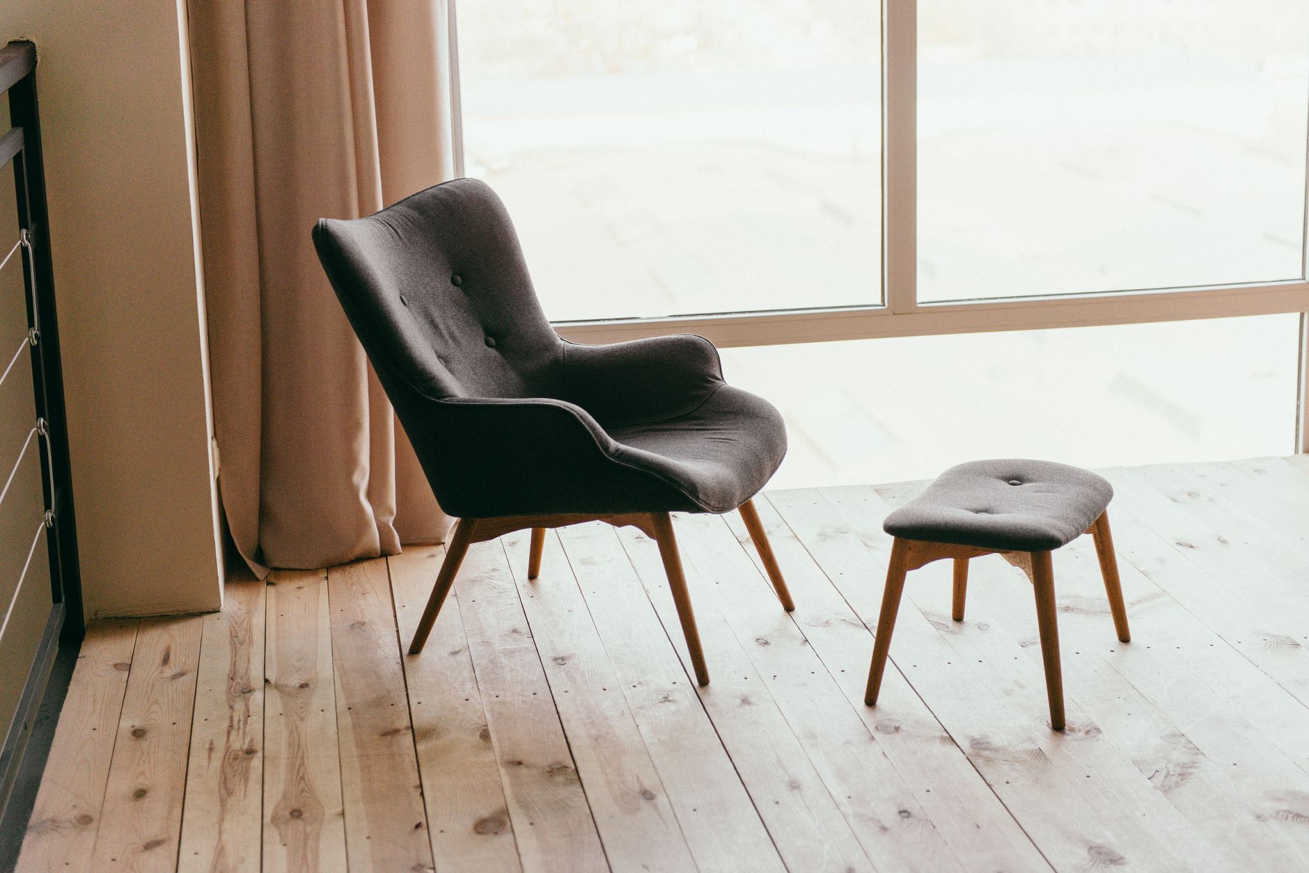 Modern relaxációs fotel lábtartóval, világos, minimalista belső térben
