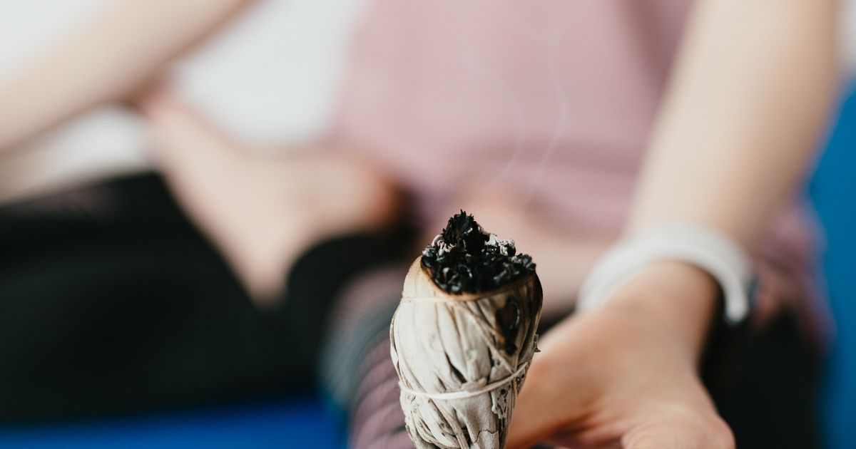 Fehér zsálya csomó (Salvia apiana) parázsló véggel és felszálló füsttel világos háttéren